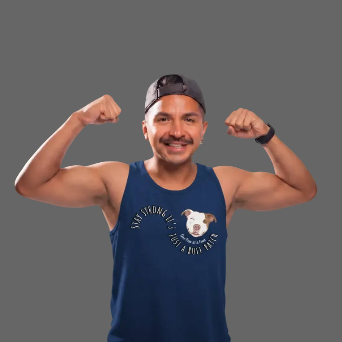 A man posing a blue tank top. The man is me the owner and founder of Smiles Fur Miles and the shirt says stay strong. It’s just a rough patch, combining mental health and Dog puns and advocacy and a reminder to you and me and rosa need to smile about and you have your grace with you and tell you to take it one part a time Riley Grace right there in your heart